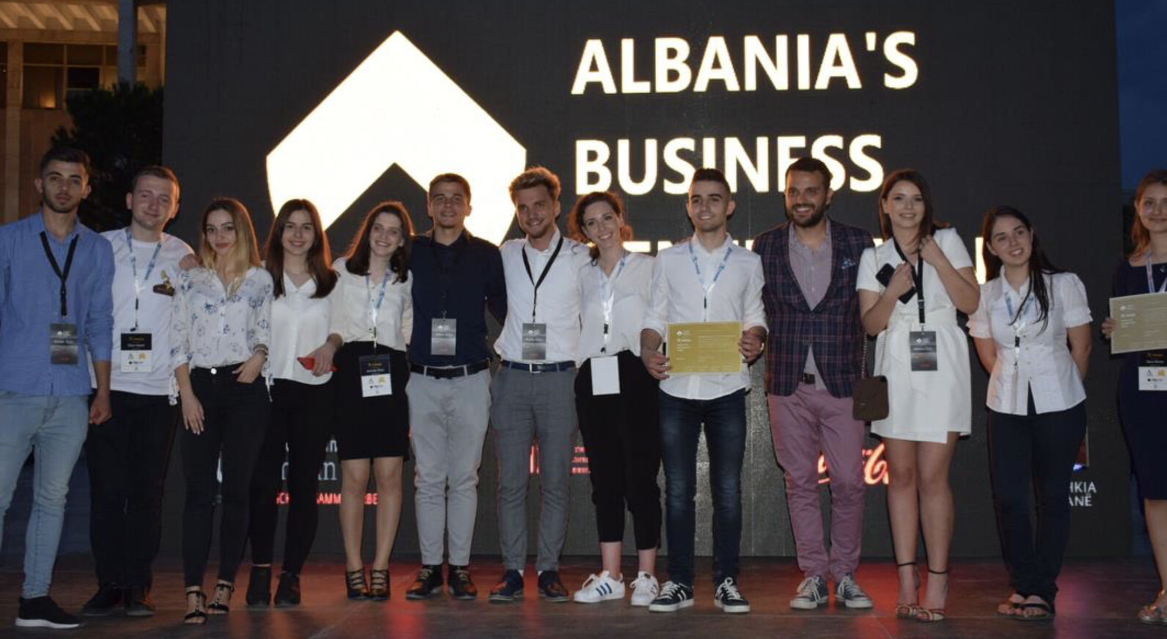 Dario Hani with a group of young entrepreneurs in front of the Albania's Business Generation sign